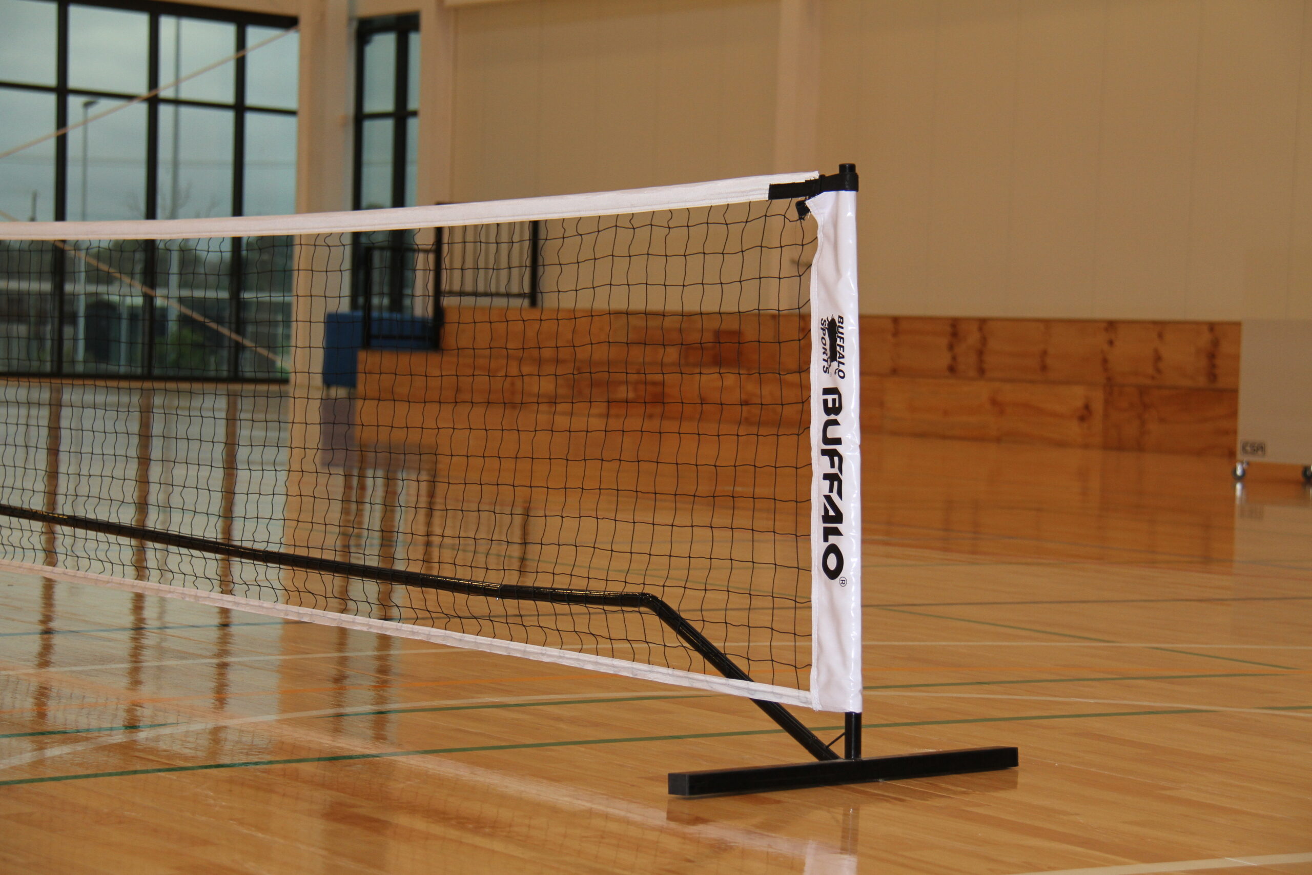Photo of pickleball net bordered with white and black in a stadium